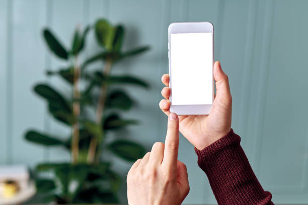 istock Woman holding and touching blank screen template smart phone. Smart phone screen is empty with clipping path. 1192491702