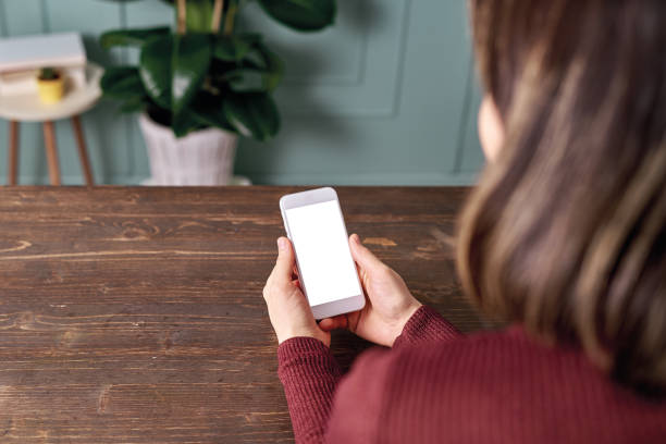 istock Woman holding and touching blank screen template smart phone. Smart phone screen is empty with clipping path. 1192491739