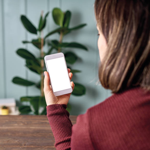 istock Woman holding and touching blank screen template smart phone. Smart phone screen is empty with clipping path. 1192491745