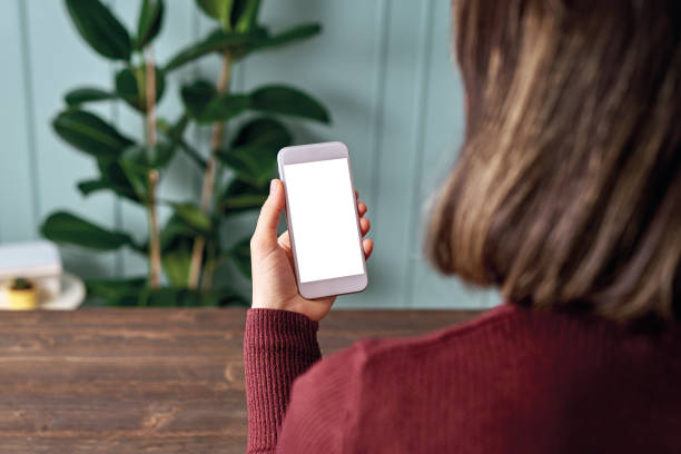 istock Woman holding and touching blank screen template smart phone. Smart phone screen is empty with clipping path. 1192491748