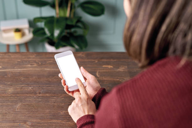 istock Woman holding and touching blank screen template smart phone. Smart phone screen is empty with clipping path. 1192491779