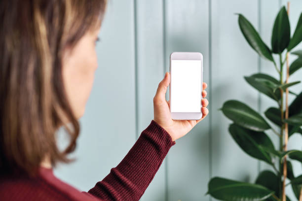 istock Woman holding and touching blank screen template smart phone. Smart phone screen is empty with clipping path. 1192491785