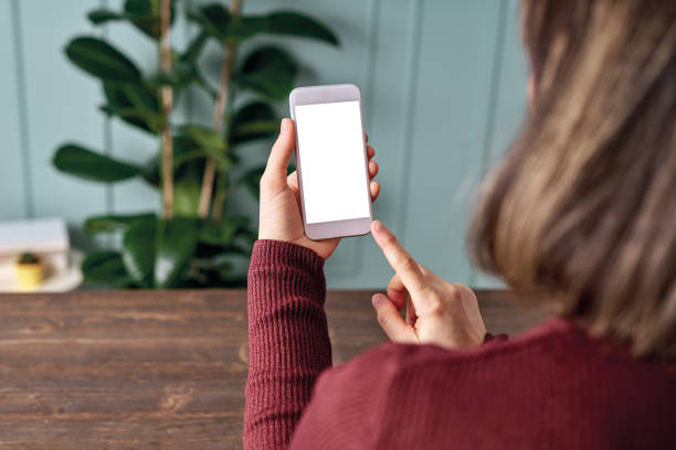 istock Woman holding and touching blank screen template smart phone. Smart phone screen is empty with clipping path. 1192491816