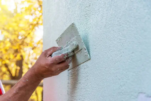 Application Of Facade Plaster,Worker Plastering The Facade Of The Building, Close-Up.