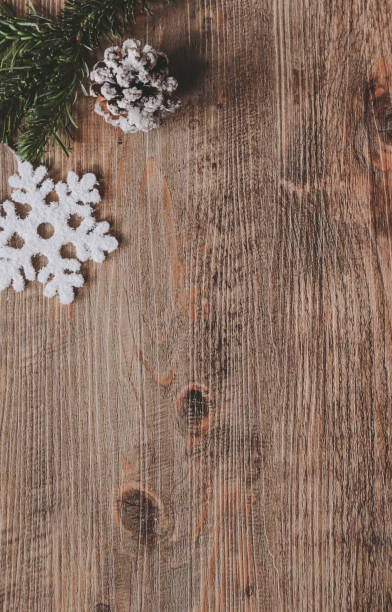 christmas themed background with snowflake and fir branch on wood background