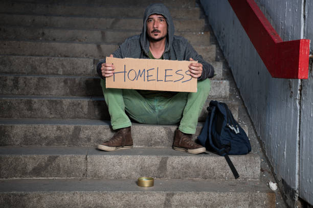 istock Desperate Beggar Sitting on the Stairs and Asking for Help 1192498929