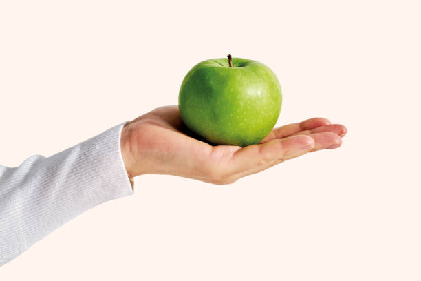 Woman hand holding green fresh apple. Green apple on white background. Hand with apple isolated.