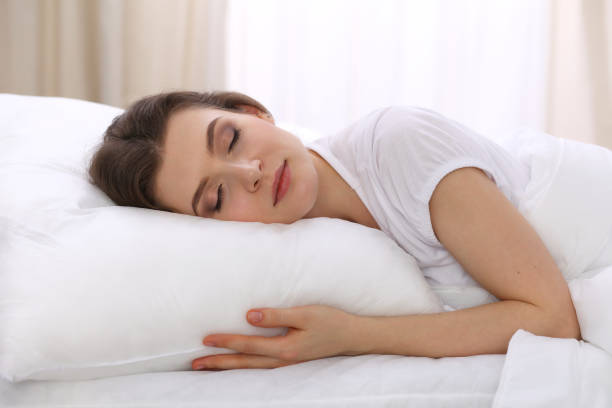 istock Beautiful young woman sleeping while lying in her bed. Concept of pleasant and rest reinstatement for active life 1192500480
