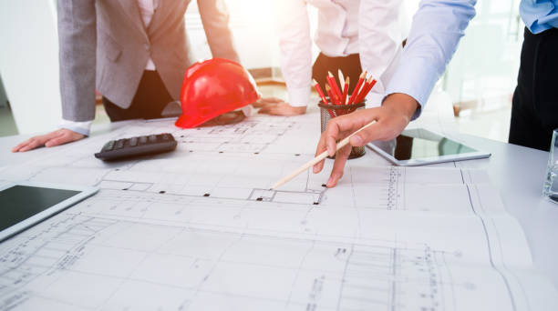 istock Group of architects and engineers discussing construction plans around a table 1192501205