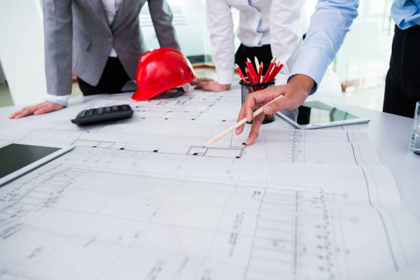 Group of architects and engineers discussing construction plans around a table