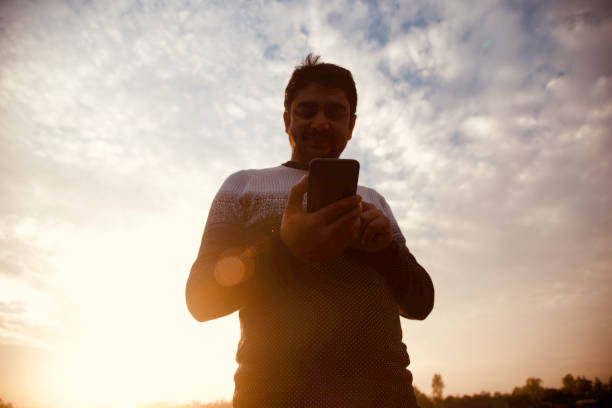 istock Man using a cellphone standing in a place in the afternoon 1192506891