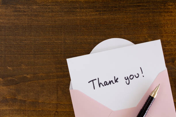 Thank you card A hand written Thank you card in a pink envelope,  on a wooden desk. gift tag note photos stock pictures, royalty-free photos & images