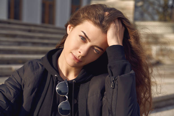 istock girl straightens curls, holding hand on head 1192508816