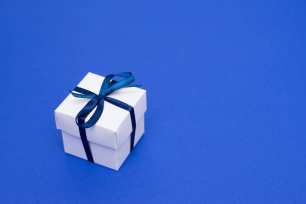 istock Present box with blue bow on blue background, greeting card with copy space 1192509043
