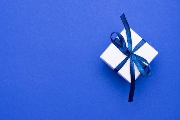 pudełko na prezent z kokardką stonowaną w klasycznym kolorze niebieskim. kolor roku 2020. kopiuj miejsce. - gift blue christmas religious celebration zdjęcia i obrazy z banku zdjęć
