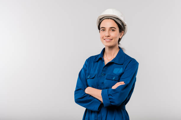 istock Happy young cross-armed female engineer in blue workwear and hardhat 1192512818