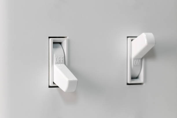 Closeup of white duplex light switch turned off and another turned on in background. Concept of energy saving, conservation detail, landscape, no people duplex photos stock pictures, royalty-free photos & images