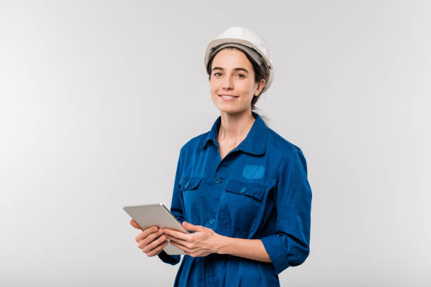 istock Smiling successful female engineer in workwear and hardhat using touchpad 1192515203