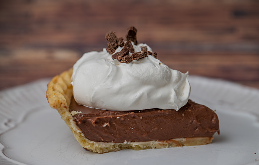 Close up of a slice of chocolate cream pie with whipped cream