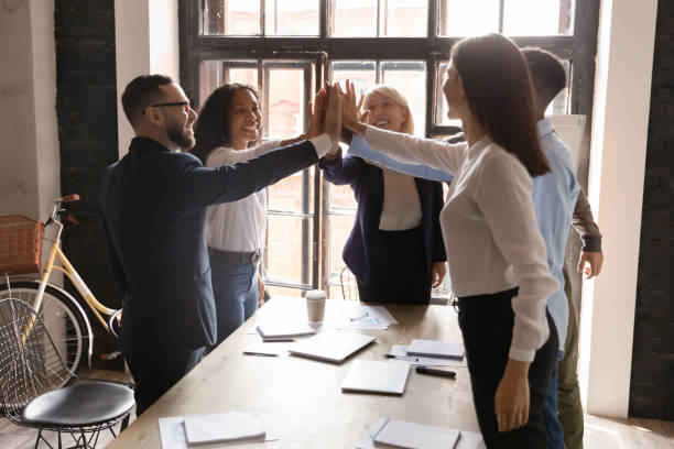istock Joyful euphoric diverse business people joining hands together in air. 1192516608
