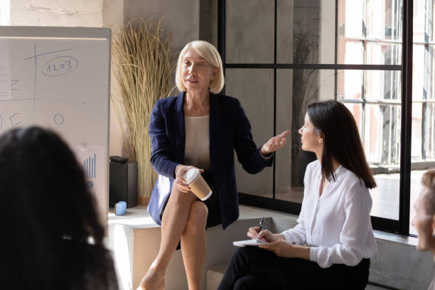 istock Mature female trainer giving educational lecture to young workers. 1192516644