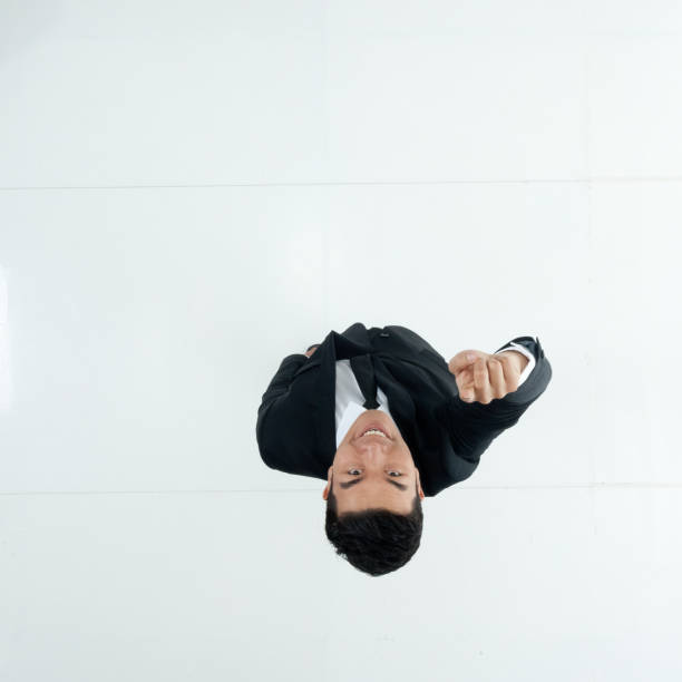 Full length / one man only / one person / directly above view / aerial view / looking at camera / looking up of adult handsome people black hair / short hair chinese ethnicity / east asian ethnicity male / young men businessman / business person standing in front of white background in the office wearing businesswear / a suit who is smiling / happy / cheerful / laughing / excited / successful and cheering / showing fist who is and doing fist pump longitud completa / un hombre solamente / una persona / directamente por encima de la vista / vista aérea / mirando a la cámara / mirando hacia arriba de la gente hermosa adulta pelo negro / pelo corto etnia china / etnia asiática oriental masculino / h