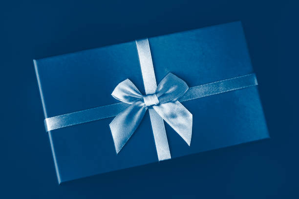istock Classic Blue color of the Year 2020. Gradient colors palette. Creative pattern box with bow on classic blue background. Holiday gift minimal concept. Top view, flat lay, close up. 1192519291