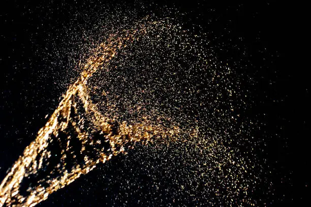 Photo of Abstract background. Splashes of yellow water similar to champagne on a dark background.