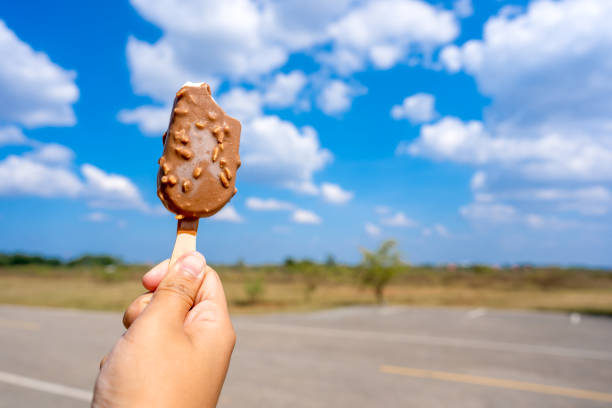 istock Ice crean on hand holding on blue sky and cloud background 1192525396