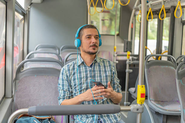 istock Young Man with Headphones in a Public Bus 1192525477