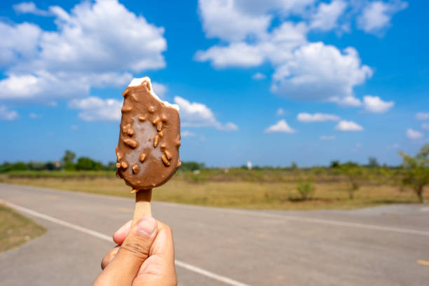 istock Ice crean on hand holding on blue sky and cloud background 1192525509