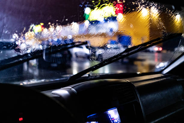 une vue de l'intérieur de la voiture du nettoyage d'essuie-glace pendant la pluie abondante de nuit - car cleaning blue water photos et images de collection
