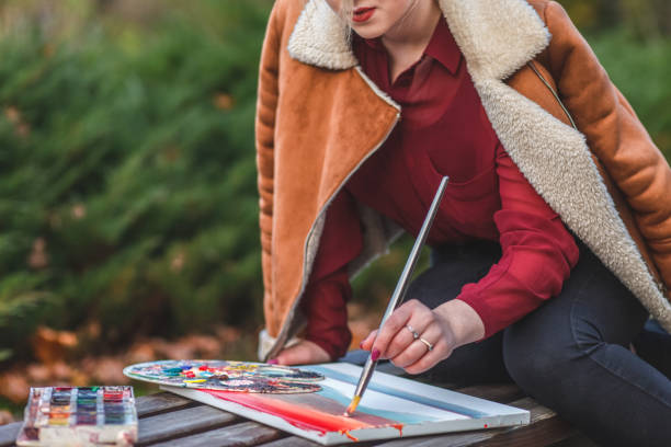 istock Young painter draws a picture sitting in a park on the bench 1192527854