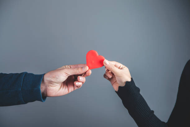 istock woman and man hands red heart 1192529074