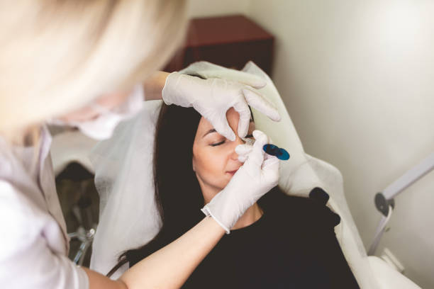 女性は鼻に美しさを注入する。美容院におけるボトックス手順 - wrinkle treatment doctor surgeon human hand ストックフォトと画像
