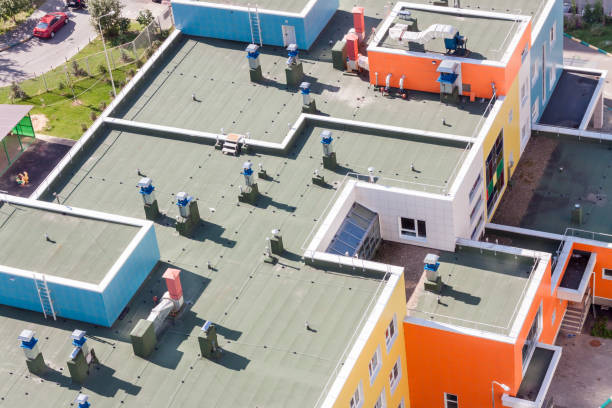 Top view flat roof with air conditioners and hydro insulation membranes on top of a modern apartment. stock photo