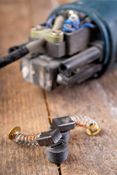 istock Brushes for electric motor on a workbench. Spare parts for angle grinders. Dark background. 1192537875