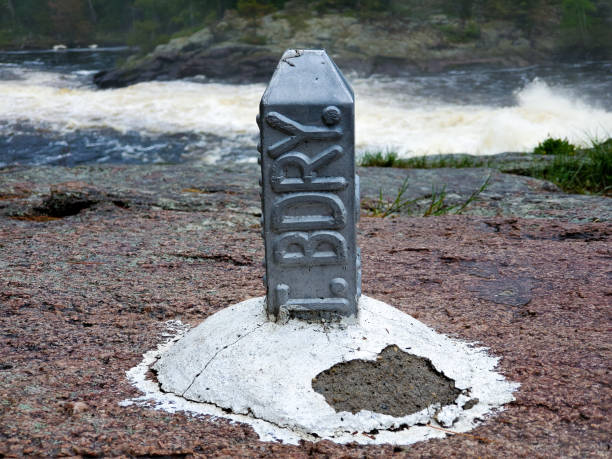 A border marker with waterfall background Beautiful waterfall on the US canada border with a border marker in the foreground boundary waters canoe area stock pictures, royalty-free photos & images