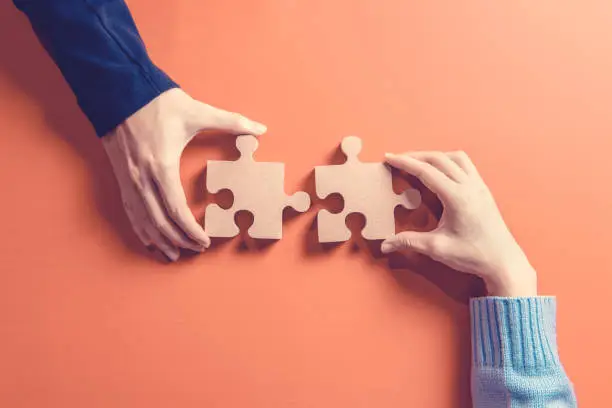 Photo of Two hands holding jigsaw, Concept for teamwork Building a success.