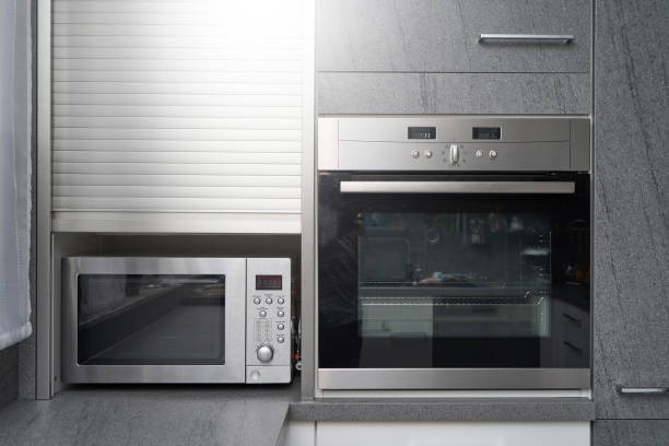 istock Metallic microwave and oven in gray kitchen interior 1192544307