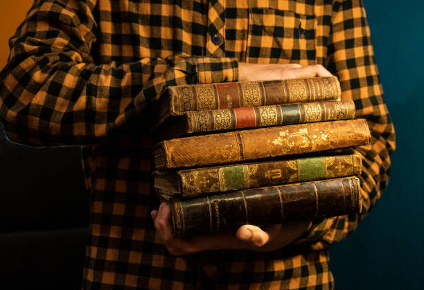 istock Young man is reading old books. 1192544462