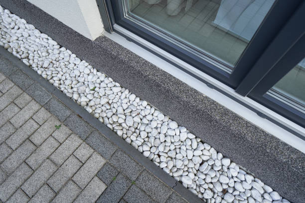 Pebbles for drainage of water along the house next to the wall. Rainwater harvesting stock photo