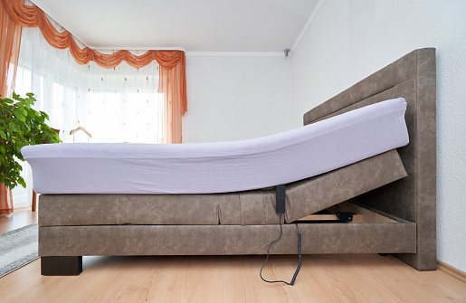 Cama con colchón de ajuste de inclinación en el dormitorio de la casa, colchón cómodo y sueño photo