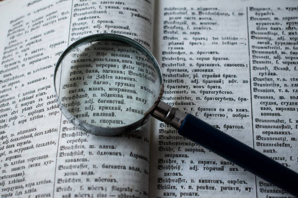 istock Old open book and magnifying glass. 1192548131