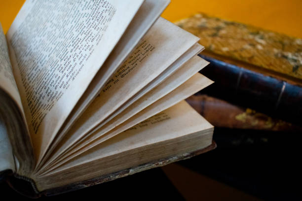 istock Old open book and magnifying glass. 1192548701