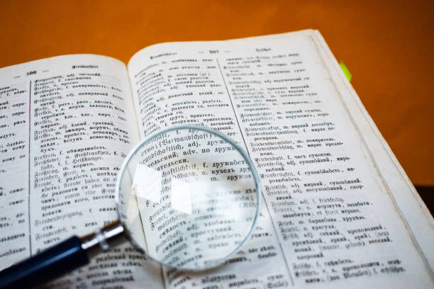 istock Old open book and magnifying glass. 1192548763