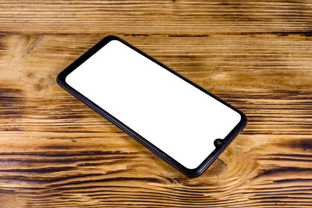 istock Modern smartphone with blank screen on a wooden background 1192551433