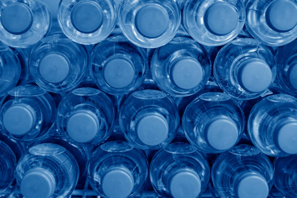 istock Rows of many transparent plastic bottles with drinking water supply in white refrigerator. Mineral water stack storage in fridge to drink summer day. Trendy color year 2020 classic blue toned 1192558424