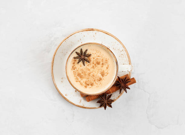 Indian Masala chai tea. Traditional Indian hot drink with milk and spices on white concrete background. Indian Masala chai tea. Traditional Indian hot drink with milk and spices on white concrete background. Top view, flat lay. chai stock pictures, royalty-free photos & images
