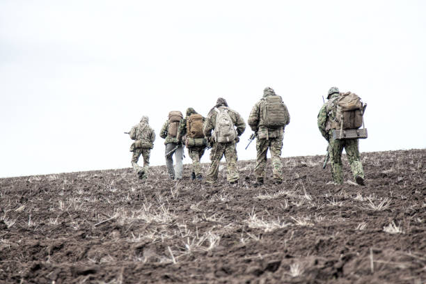 istock Army soldiers group on march in muddy field 1192563336